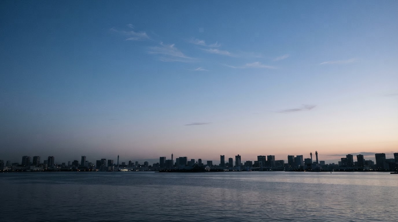 晴れ渡った朝の空、薄い雲の切れ端がいくつか散らばり、その下に都市の輪郭がかすかに見える(AI生成画像)