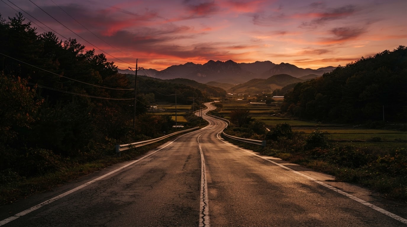 夕暮れどきの、がらんとした地方の道路。長く伸びるアスファルトの上に赤く染まる空 (AI生成画像)
