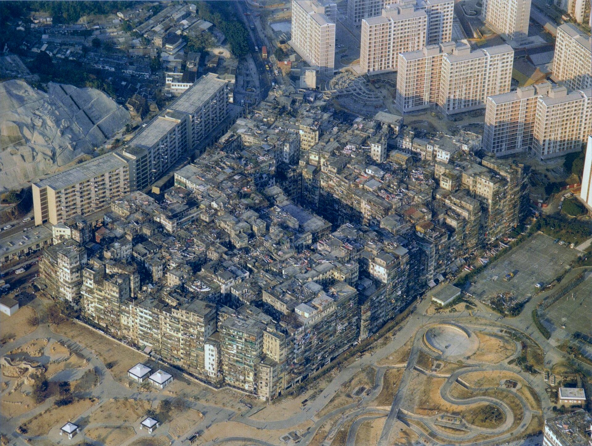 Kowloon Walled City seen from the air shortly before demolition, the whole 2.6-hectare site fused into a single mass.