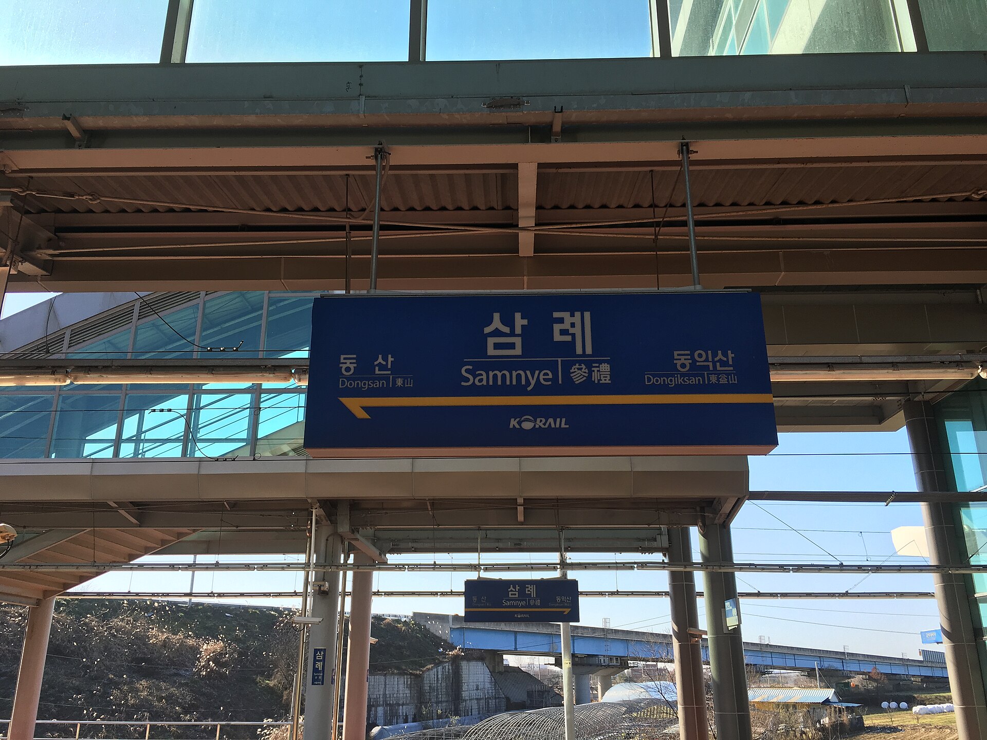 三礼駅ホームの駅名標 ― 現場一帯の実景(Wikimedia Commons)
