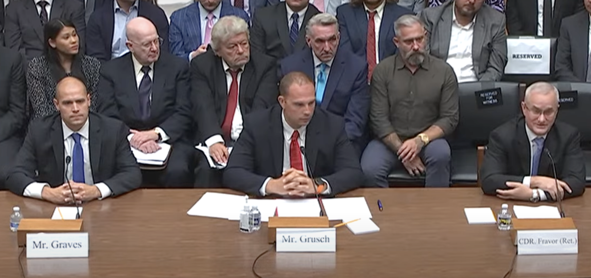 The three witnesses seated side by side at the hearing — pilot Ryan Graves, David Grusch, and David Fravor. (U.S. House of Representatives, Public Domain)
