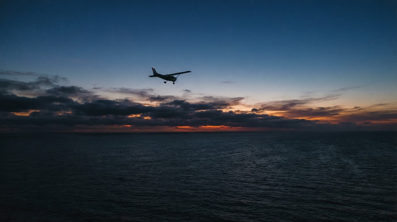 暮れなずむ夕空の下、海の上に一機の小さな単発機がぽつんとシルエットで浮かぶ光景(AI生成画像)